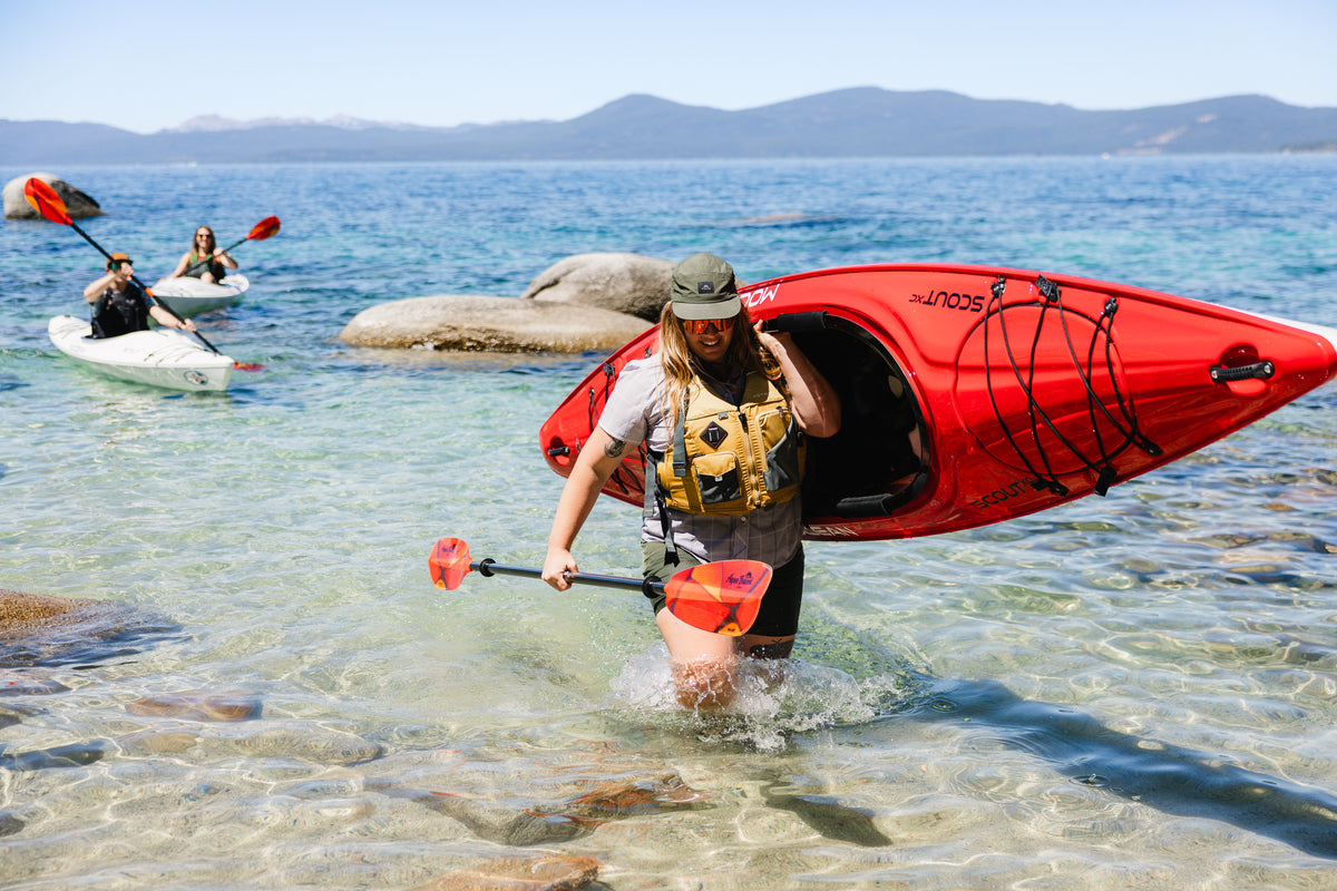 Kayaker carrying Mocean Scout XC Kayak to Shore